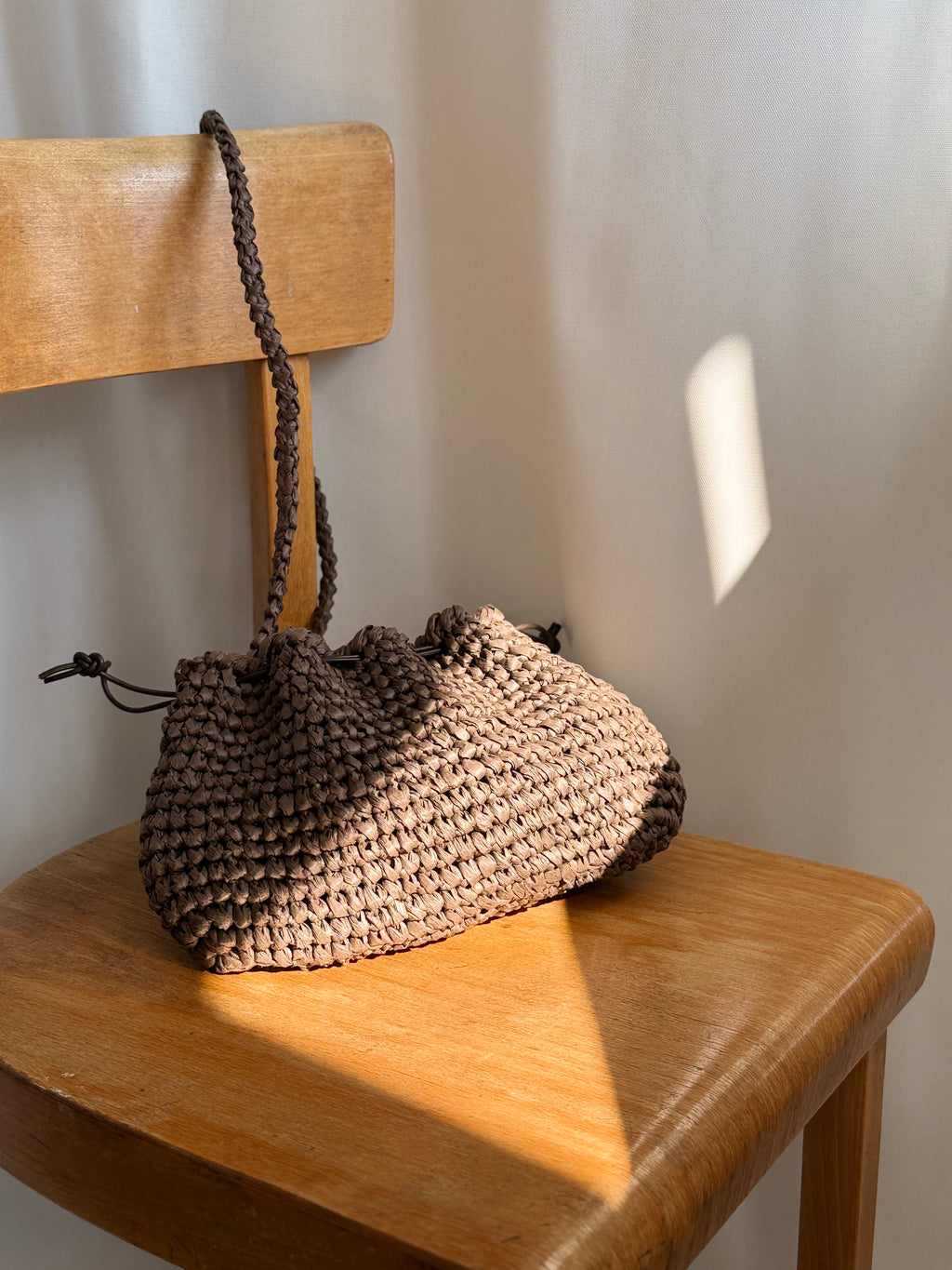 pouch von arc bags in braun. sie hängt an einer Stuhl lehne. 