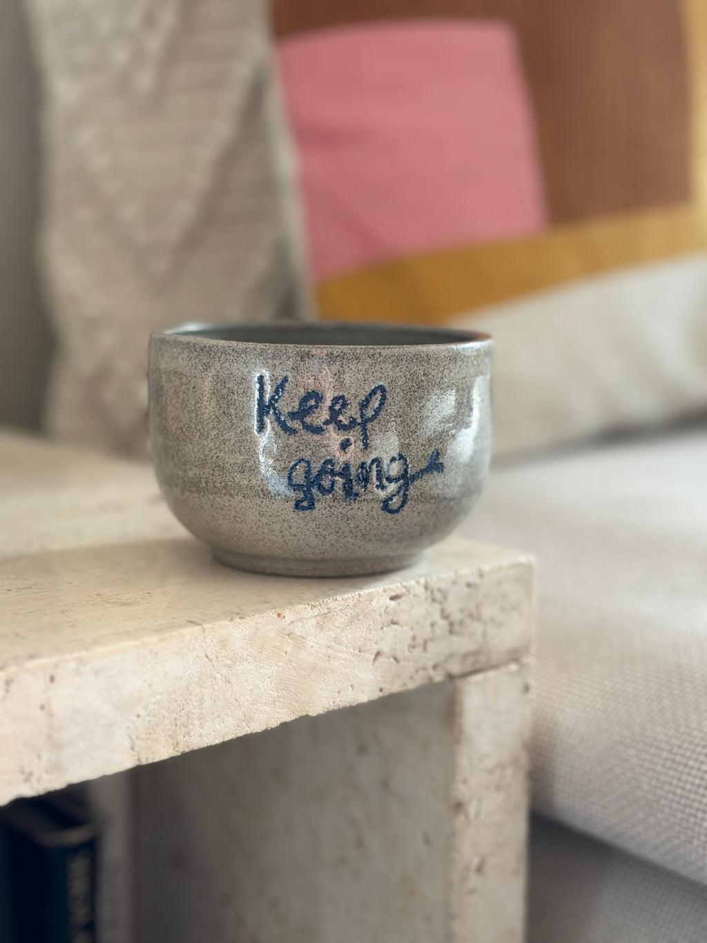Keramikbecher aus grauem Beton Ton mit der blauen Aufschrift "Keep Going"