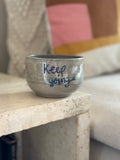 Keramikbecher aus grauem Beton Ton mit der blauen Aufschrift "Keep Going"