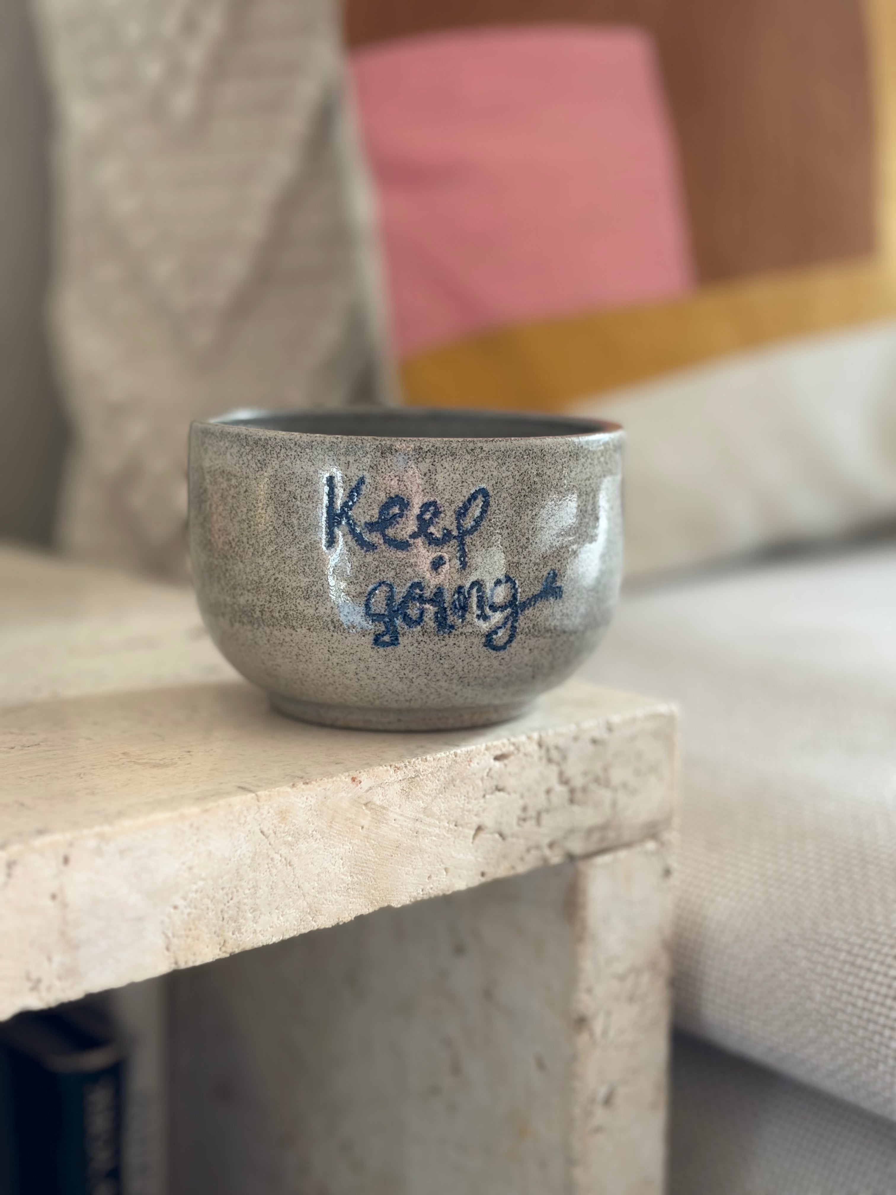 Keramikbecher aus grauem Beton Ton mit der blauen Aufschrift "Keep Going"