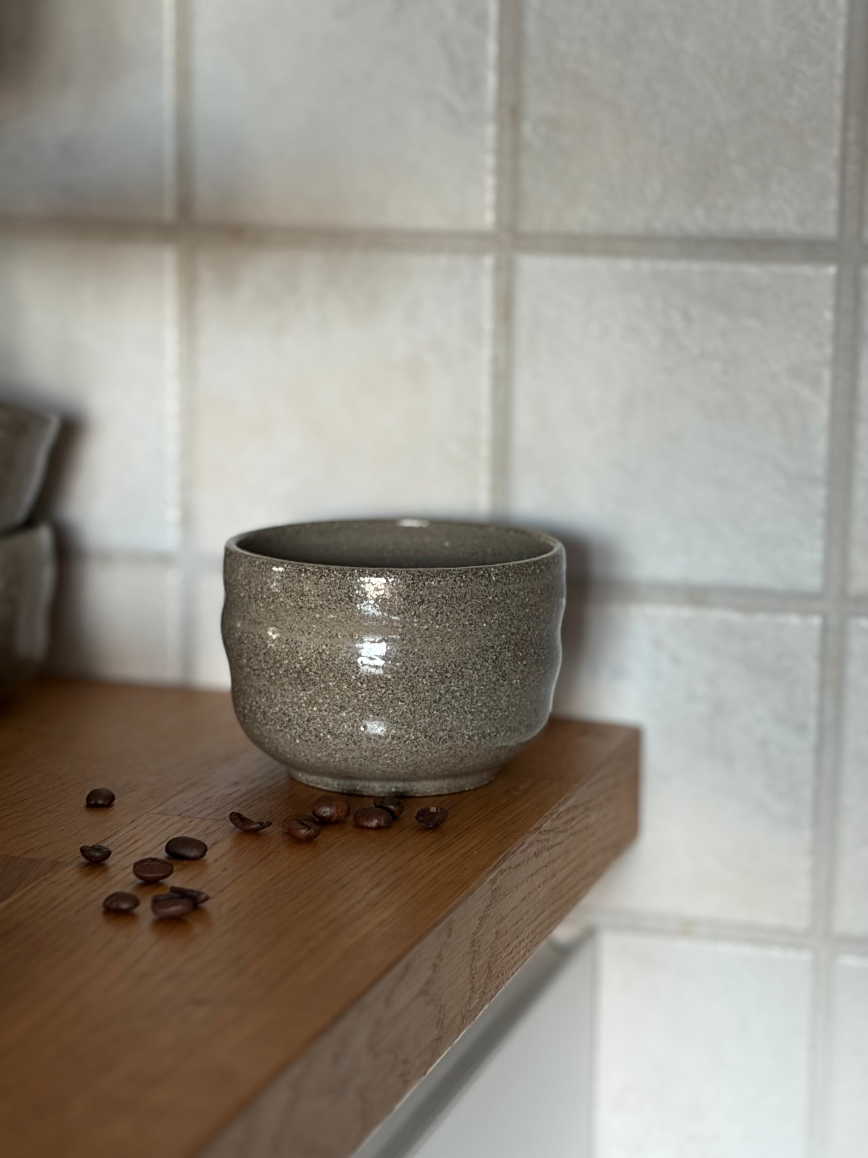 ein Keramikbecher aus betongrauem ton in Kaffe ecke 