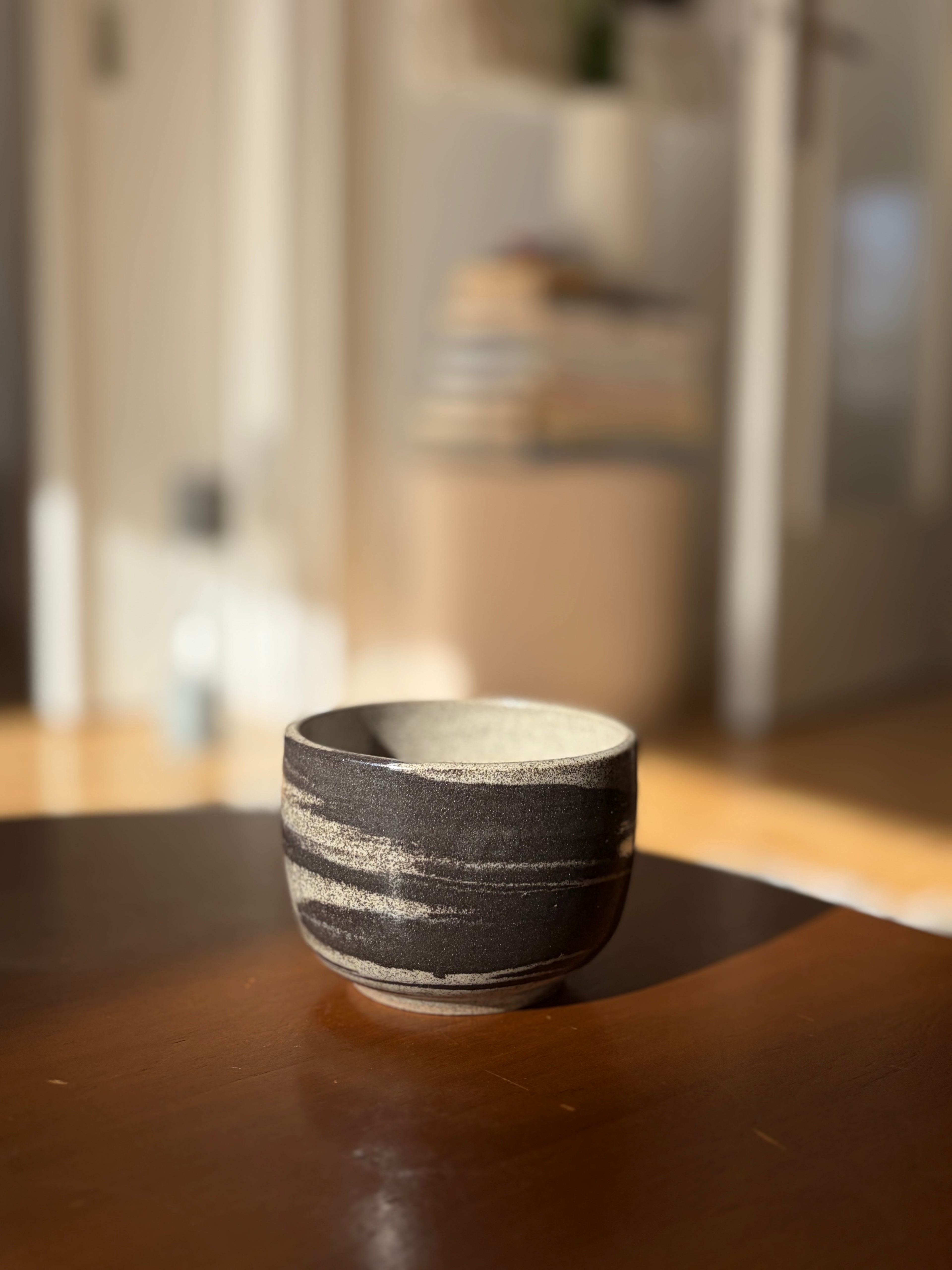 handgedrehter Keramikbecher aus marmoriertem ton, in der sonne 