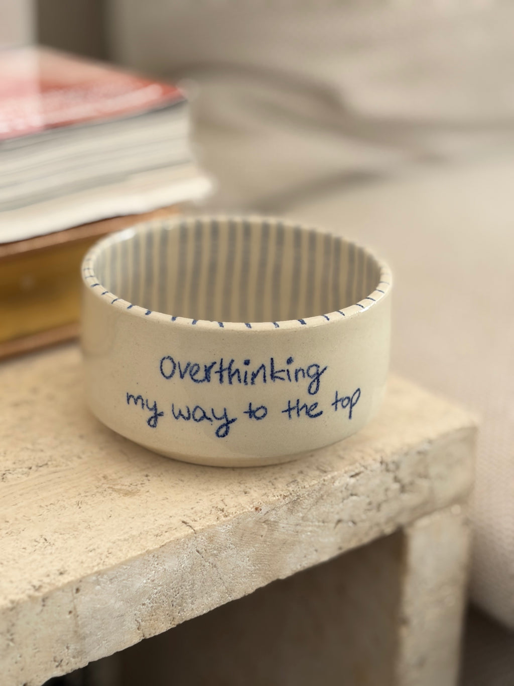 ein transparent glasierter handgemachter Keramikbecher mit einer blauen Aufschrift "overthinking my way to the top". von innen ist der Becher blau gestreift 